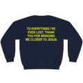A navy blue crewneck sweatshirt with bold yellow text on the chest that reads, 'TO EVERYTHING I'VE EVER LOST, THANK YOU FOR BRINGING ME CLOSER TO JESUS.'.