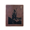 A brown leather-bound book or journal featuring a black silhouette graphic of a shepherd holding a staff, with a small gold cross in the upper right corner, shown on a plain white background.