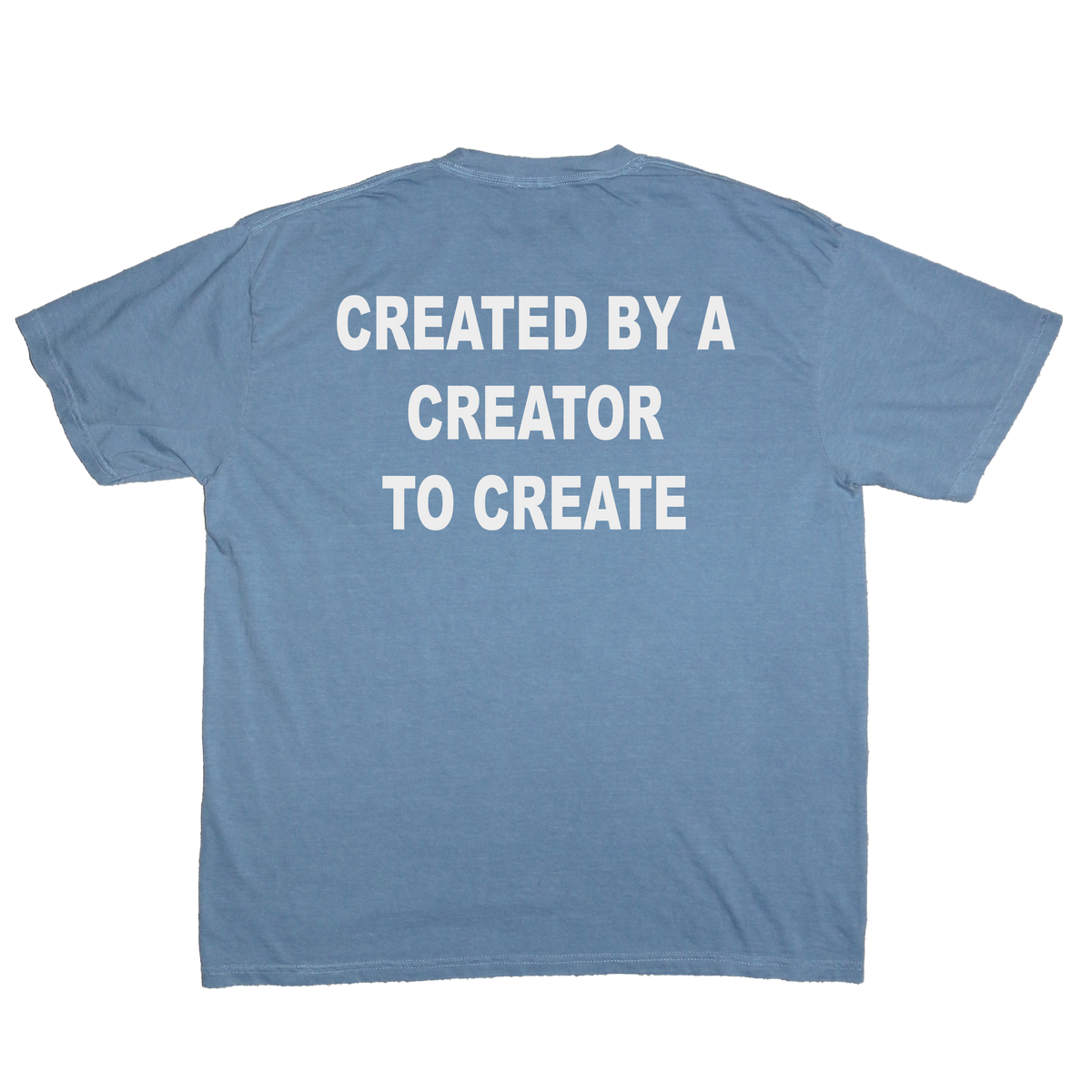 A light blue crewneck t-shirt shown from the back, featuring the phrase 'CREATED BY A CREATOR TO CREATE' printed in bold white capital letters across the upper back.