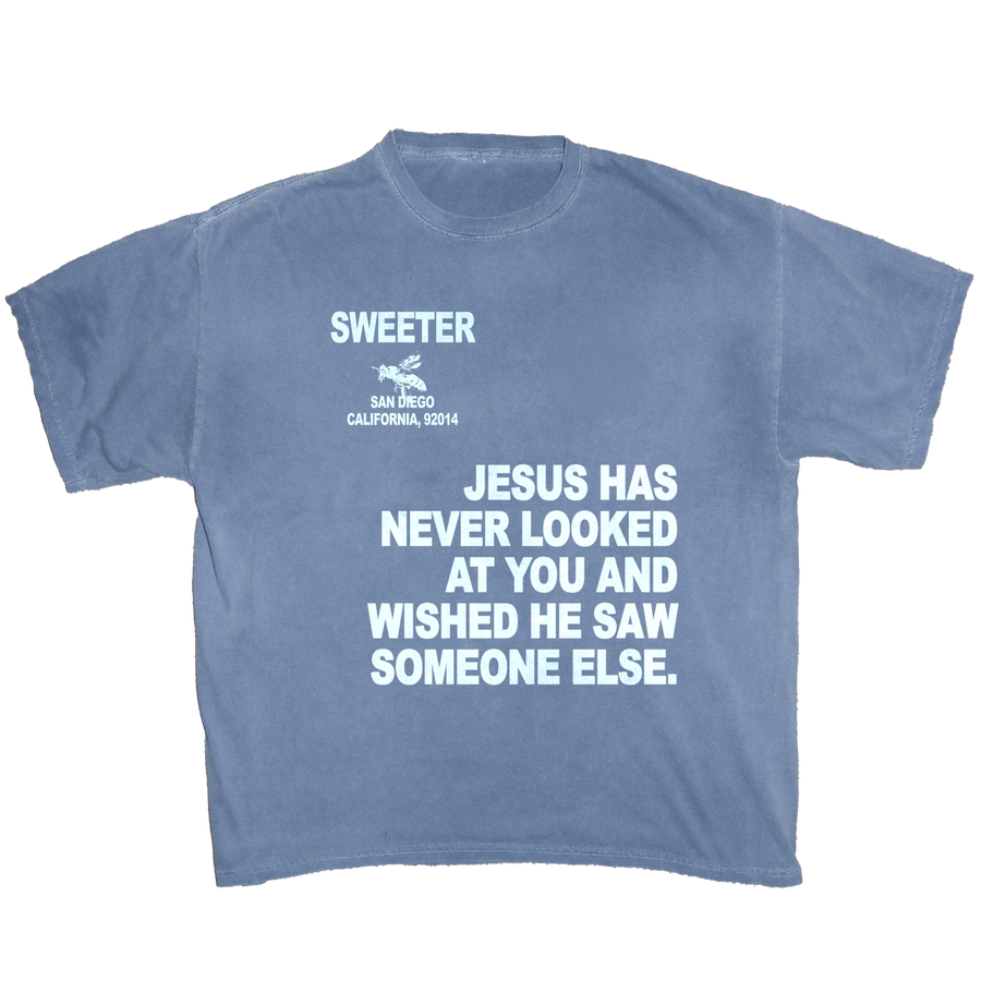 A faded blue crewneck t-shirt with white printed text on the front. The text reads 'SWEETER SAN DIEGO CALIFORNIA, 2014' above a silhouette of a cowboy riding a horse, and 'JESUS HAS NEVER LOOKED AT YOU AND WISHED HE SAW SOMEONE ELSE.