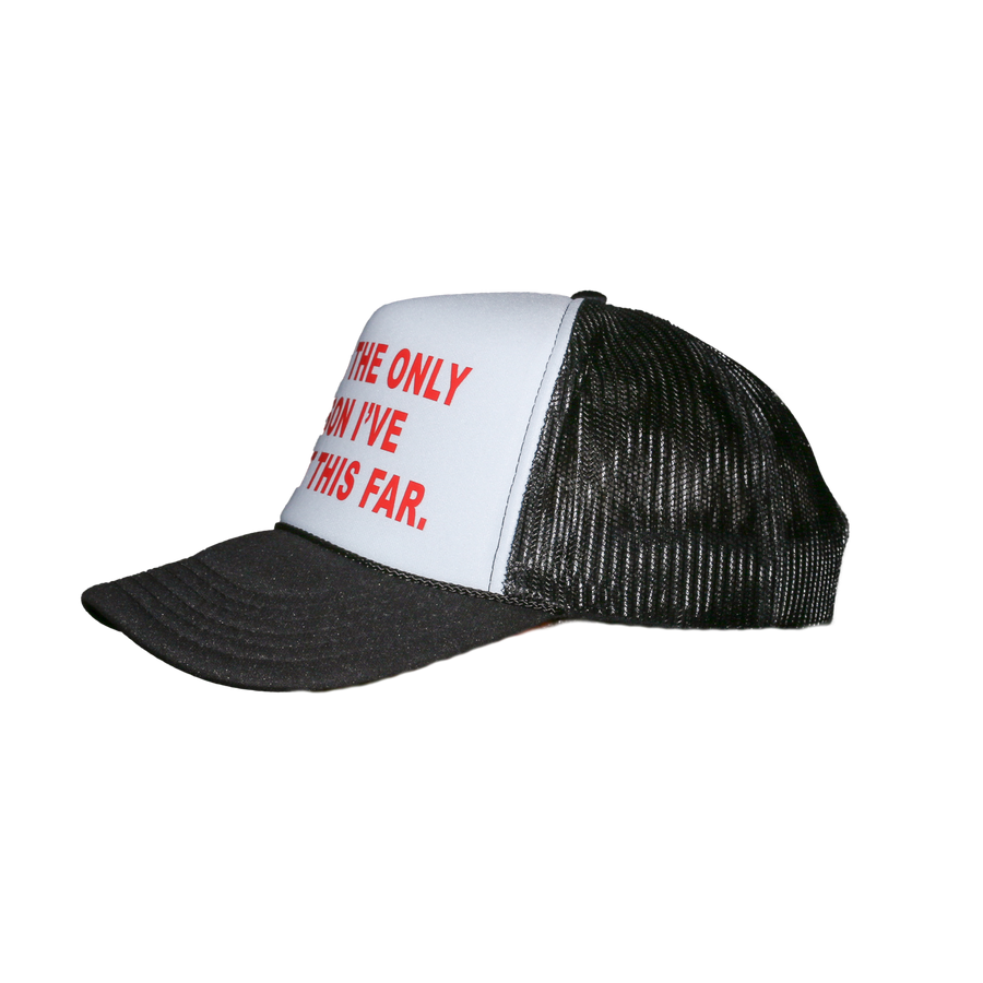 A black and white trucker hat with red text on the front panel, shown against a plain white background.