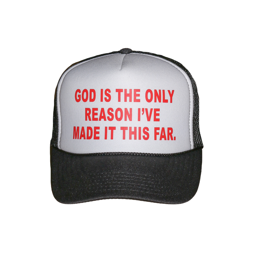 A black and white trucker hat with red text on the front panel that reads 'GOD IS THE ONLY REASON I'VE MADE IT THIS FAR.'