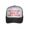 A black and white trucker hat with red text on the front panel that reads 'GOD IS THE ONLY REASON I'VE MADE IT THIS FAR.'