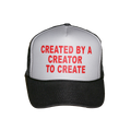 A black and white trucker hat with red text on the front panel that reads 'CREATED BY A CREATOR TO CREATE'.