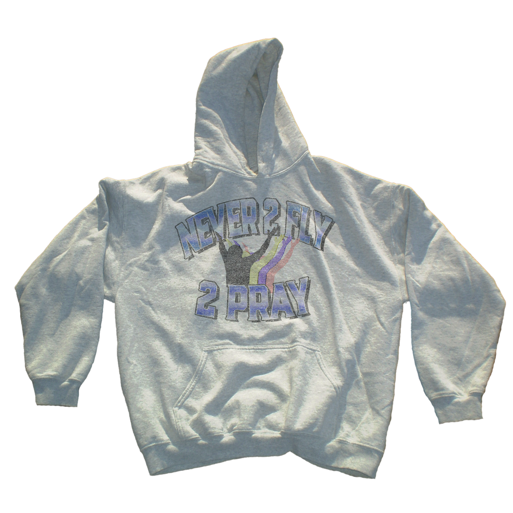 A light gray heather pullover hoodie featuring a front graphic with the text 'NEVER 2 FLY 2 PRAY' in blue and purple outlined lettering, with a black silhouette of a person praying and a small rainbow accent.